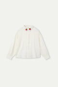 Camicia bianca da bambina con colletto ricamato a forma di fragola.